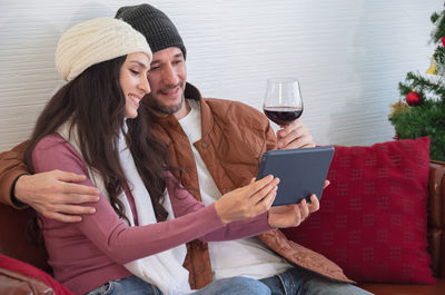 Couple holding hands while sitting on mobile phone