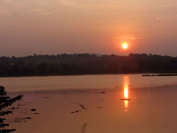 Scenic view of lake against orange sky