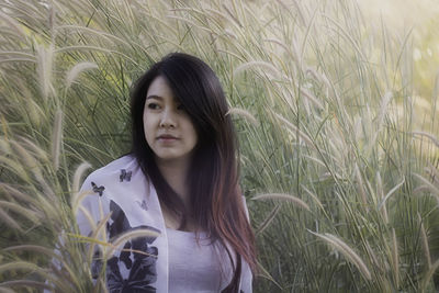 Portrait of beautiful young woman on field