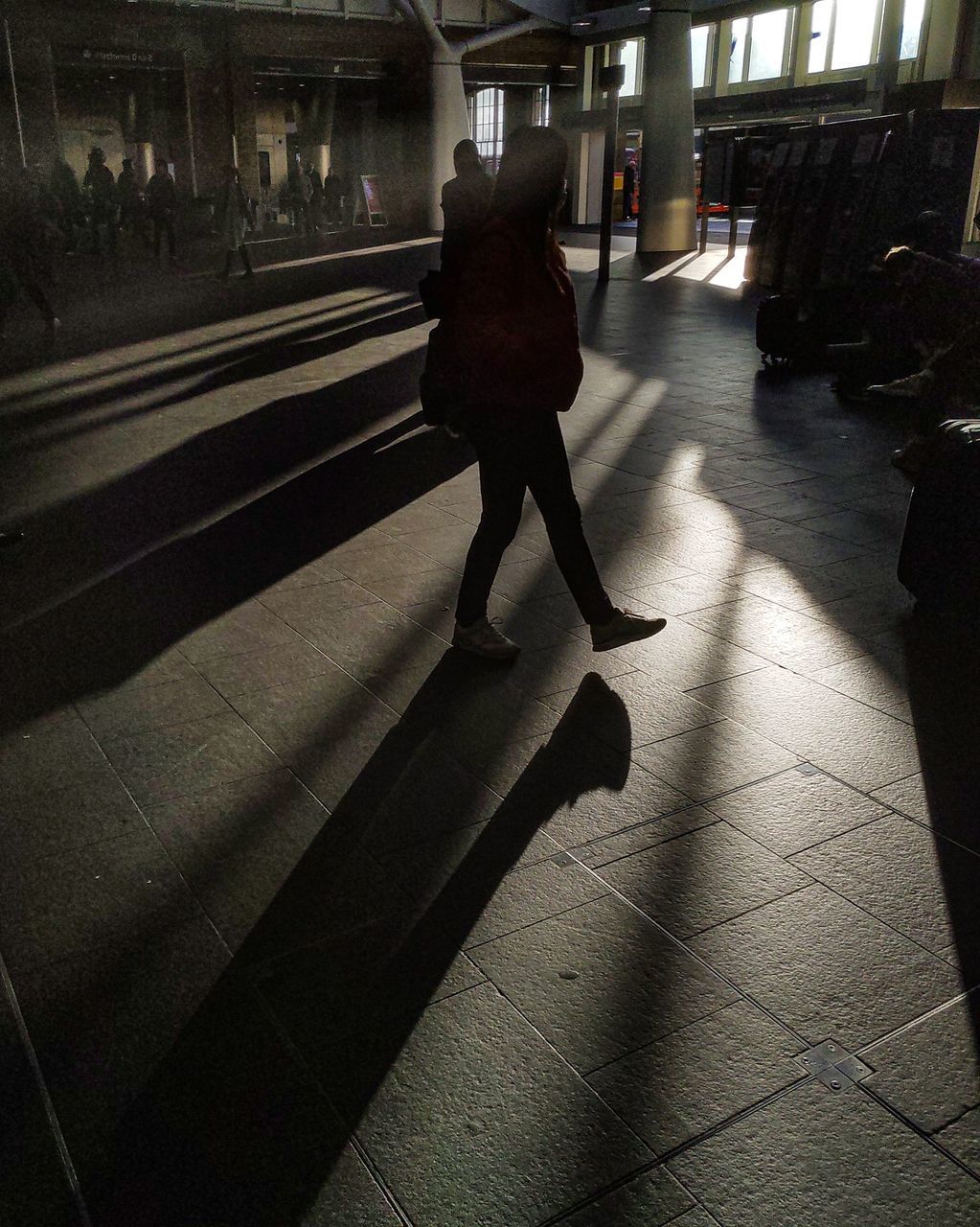 shadow, real people, walking, full length, one person, sunlight, transportation, women, rear view, day, adult, architecture, lifestyles, nature, railroad station, incidental people, indoors, built structure, city, flooring, tiled floor