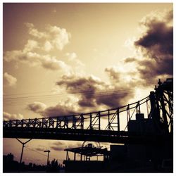 Low angle view of bridge against cloudy sky