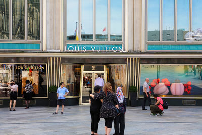 People walking on street against buildings