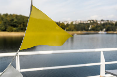 Close-up of yellow flag against sky