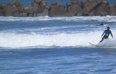 Silhouette of people surfing in sea