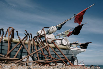 Low angle view of flags on beach against sky