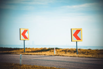 Road sign against sky