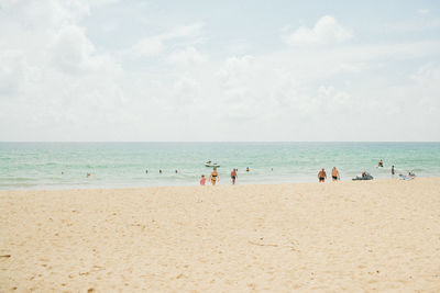People at beach against sky