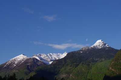 Scenic view of snowcapped mountains against blue sky