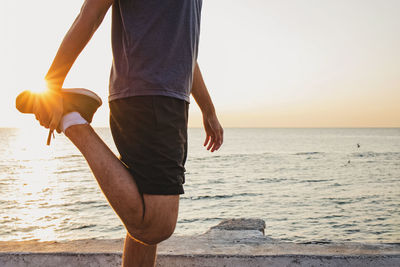 Low section of woman standing at beach