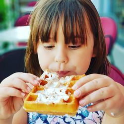 Close-up of cute girl eating waffle