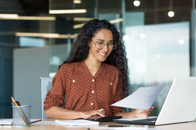 Young businesswoman using laptop at office