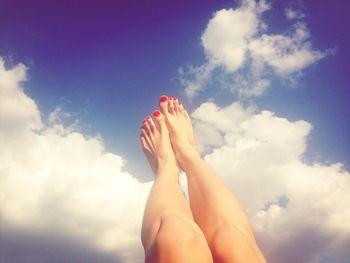 Low section of person standing against cloudy sky