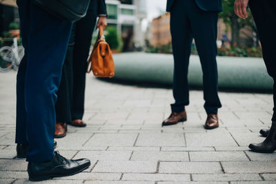 Low section of business people standing on footpath in city