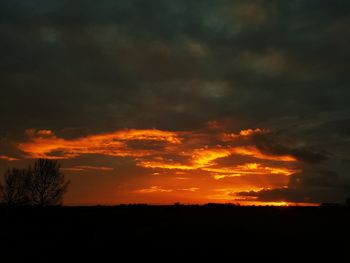 Scenic view of silhouette landscape against orange sky