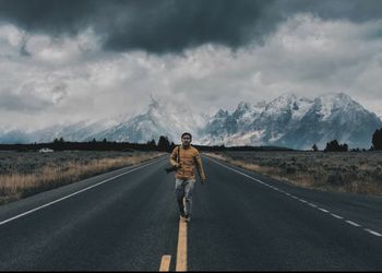 Rear view of man standing on road