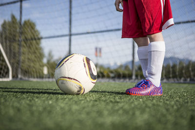 Low section close-up of young adult standing in soccer pitch