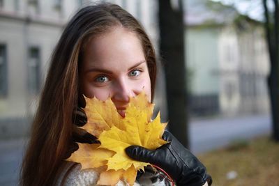 Portrait of woman holding autumn leaves