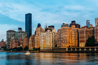 River by buildings against sky in city