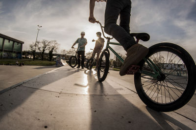 Low section of man riding bicycle on street