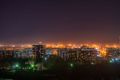 Illuminated buildings against sky at night