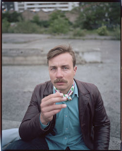 Portrait of young man smoking outdoors