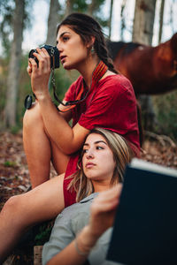 Female friends looking away in forest