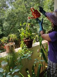 Woman standing by potted plants