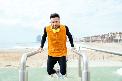 Portrait of young man exercising on railing