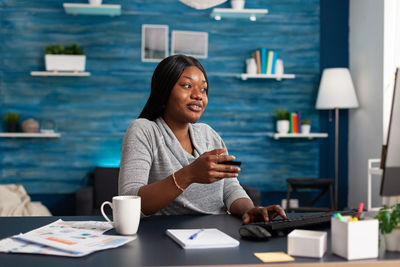 Woman shopping online while sitting at home