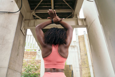 Rear view of woman stretching outdoors