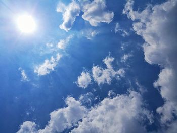 Low angle view of sunlight streaming through clouds