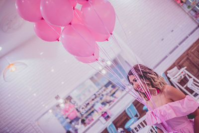 Woman with pink balloons in restaurant