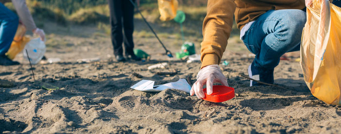 Low section of people cleaning at beach