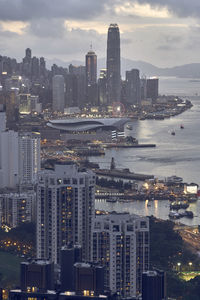 Illuminated modern buildings in city against sky