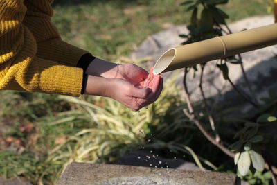 Close-up of woman with hands cupped holding water