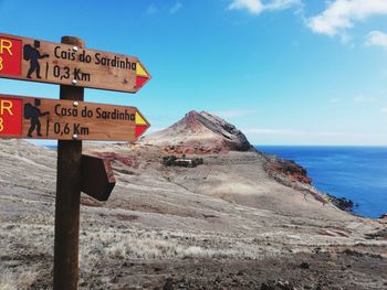 Information sign on land against sky