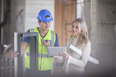 Construction worker talking to woman on construction site