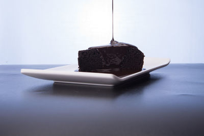 Close-up of chocolate cake on table against white background