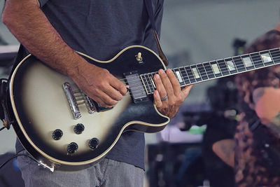 Midsection of man playing guitar