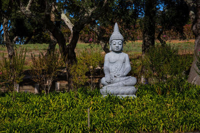 Statue against trees and plants