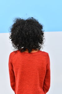 Rear view of woman with curly hair standing against white background