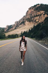 Portrait of young woman standing on road