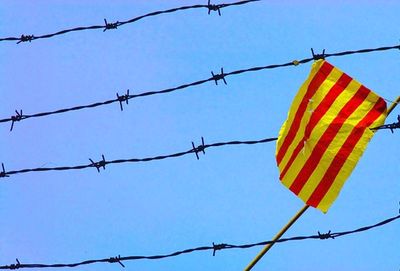 Low angle view of barbed wire against blue sky