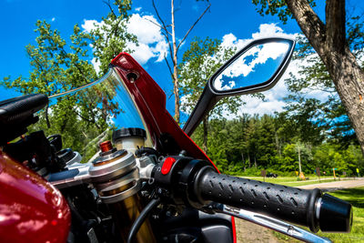 Close-up of motorcycle against blue sky