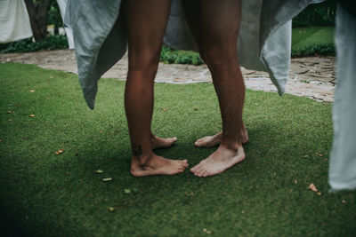 Low section of man standing on grass