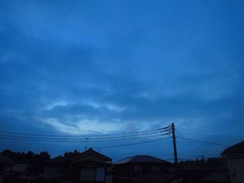 Low angle view of silhouette electricity pylon against sky