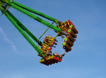 Low angle view of amusement park ride against blue sky