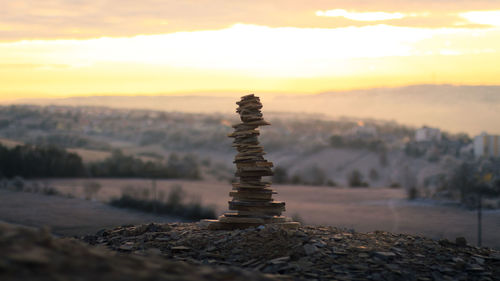 Close-up of stack of rocks against sky during sunset