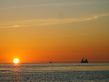 Sailboat sailing on sea against sky during sunset