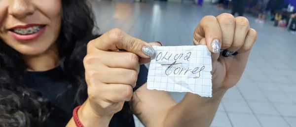 Midsection of woman holding paper with text